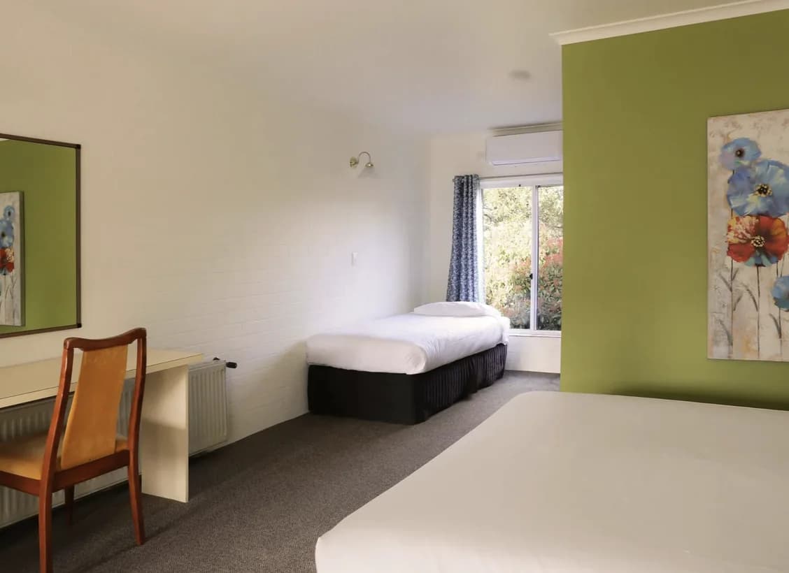 Family Room with a queen bed, two single beds by the window, a desk and chair and a flower print.