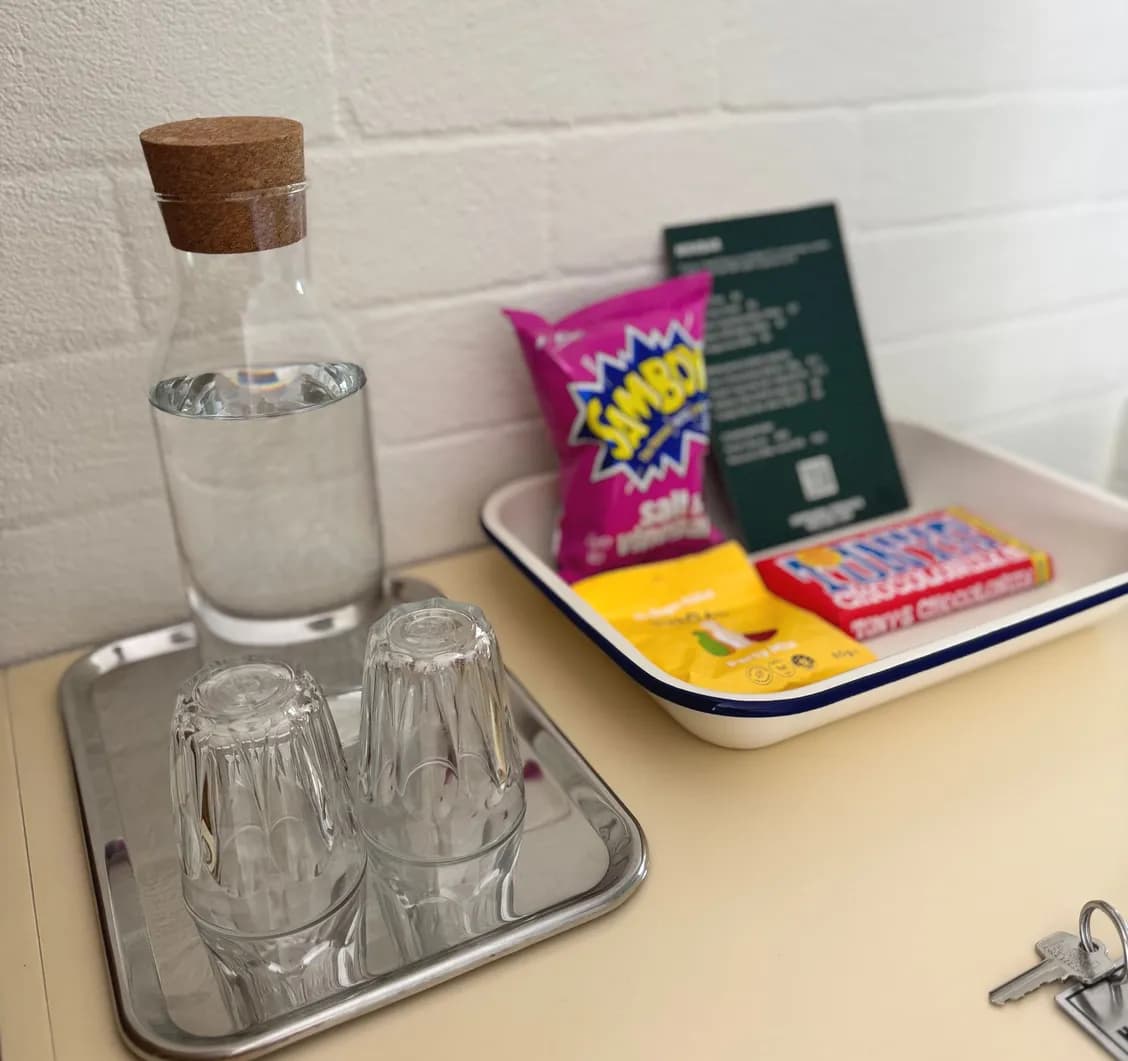 Welcome tray with a carafe of water, two glasses, snacks and the room key.